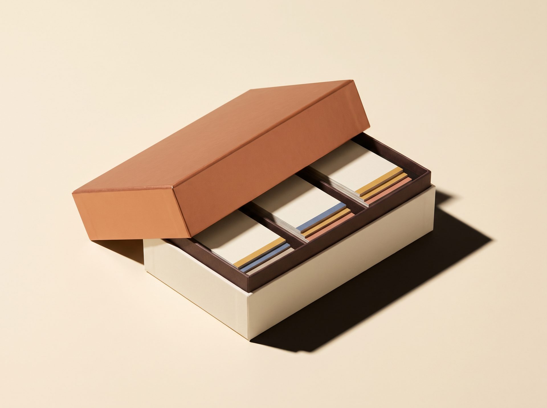 An open bento-style kit with a copper lid, its compartments holding stacked workflow cards